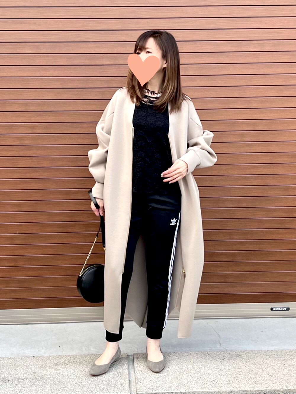 ブラック系のスウェットパンツ、ブラック系のショルダーバッグ、グレー系のパンプスを着用したレディースの春コーディネートの1枚目の写真