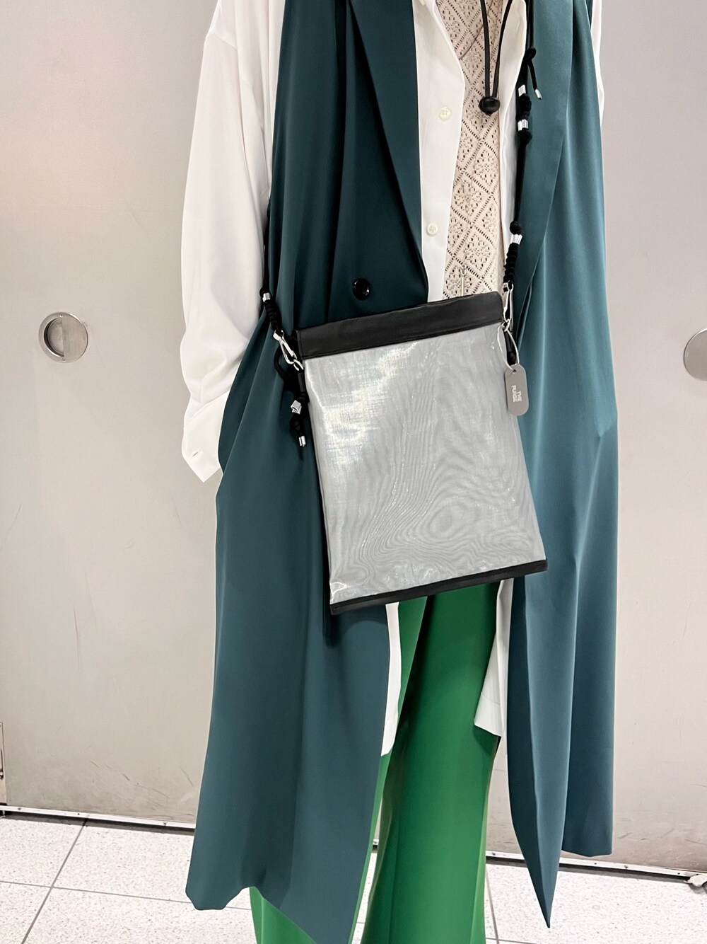 ホワイト系のシャツ/ブラウス、グリーン系のスラックス、ブラック系のブーツを着用したメンズの春コーディネートの3枚目の写真