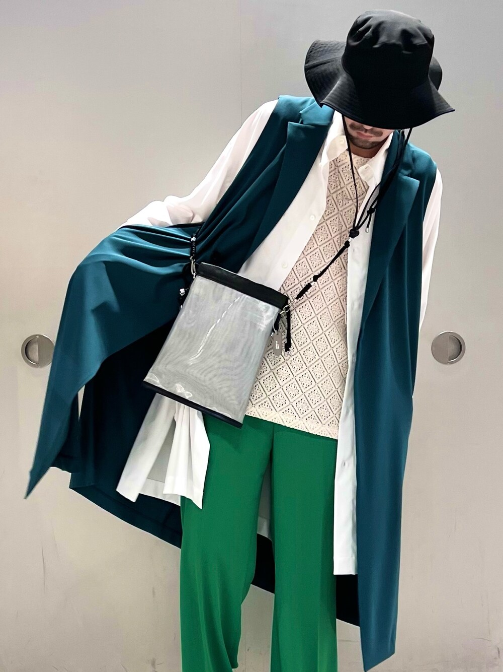 ホワイト系のシャツ/ブラウス、グリーン系のスラックス、ブラック系のブーツを着用したメンズの春コーディネートの2枚目の写真