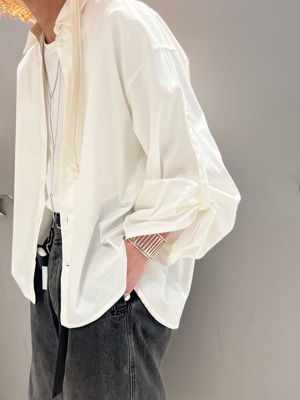 グレー系のパンツ、ブラック系のスニーカー、ホワイト系のシャツ/ブラウスを着用したメンズの春コーディネートの4枚目の写真