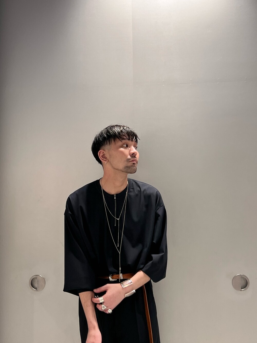 ブラック系のTシャツ/カットソー、ブラック系のショルダーバッグ、ブラック系のスラックスを着用したメンズの春コーディネートの2枚目の写真