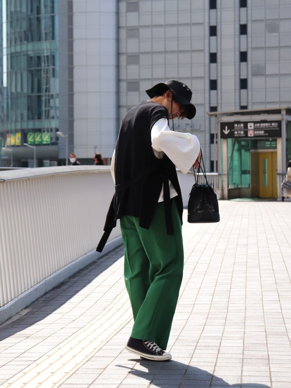 ホワイト系のTシャツ/カットソー、ブラック系のニット/セーター、グリーン系のその他パンツを着用したメンズの春コーディネートの2枚目の写真