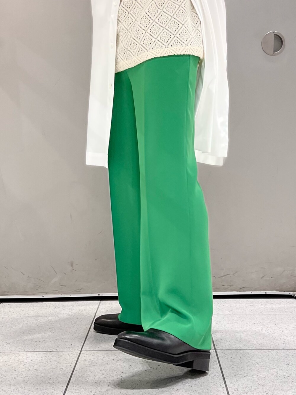 ホワイト系のシャツ/ブラウス、グリーン系のスラックス、ブラック系のブーツを着用したメンズの春コーディネートの5枚目の写真