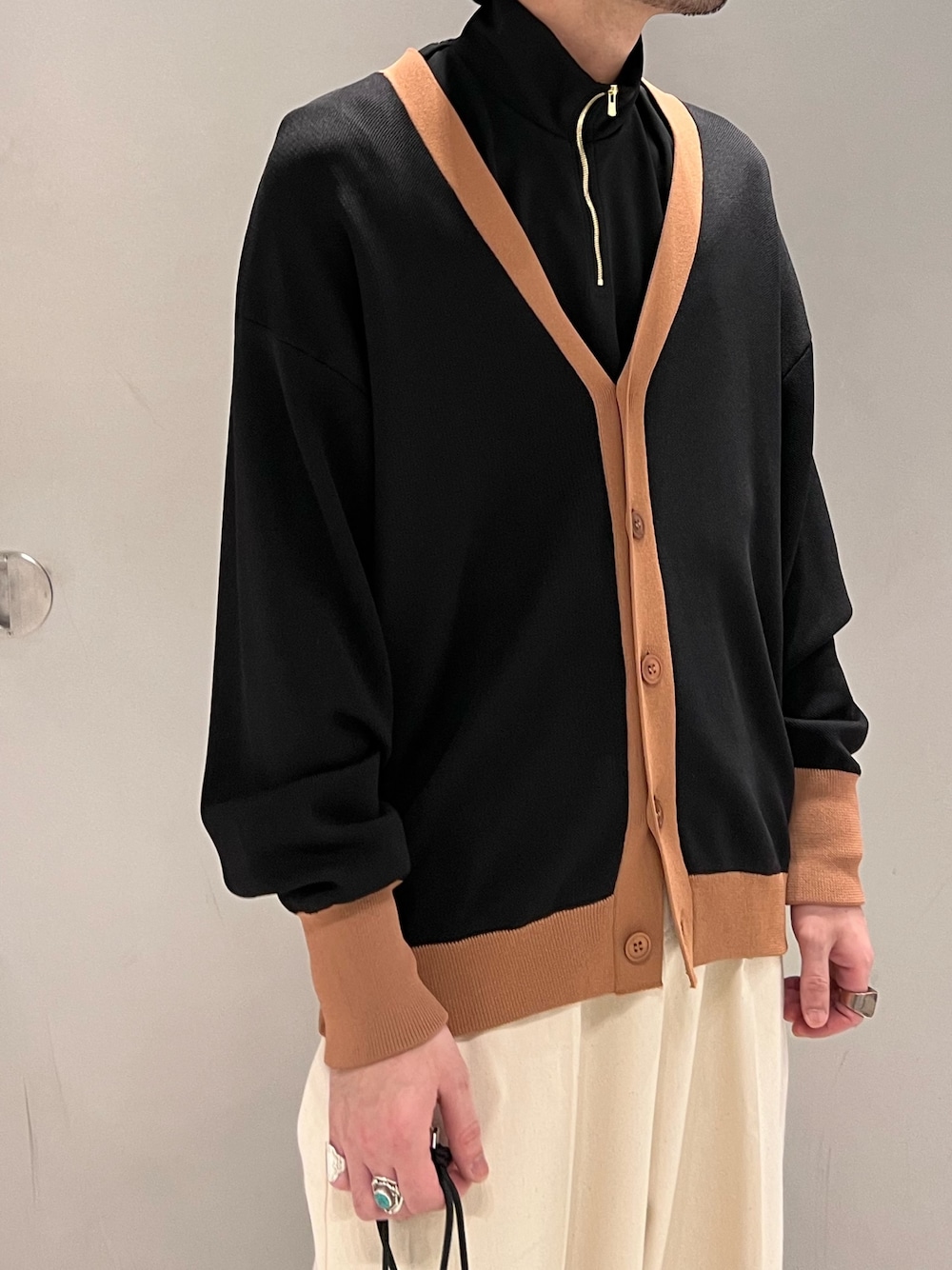 ブラック系のカーディガン/ボレロ、ブラック系のTシャツ/カットソー、ホワイト系のデニムパンツを着用したメンズの春コーディネートの3枚目の写真