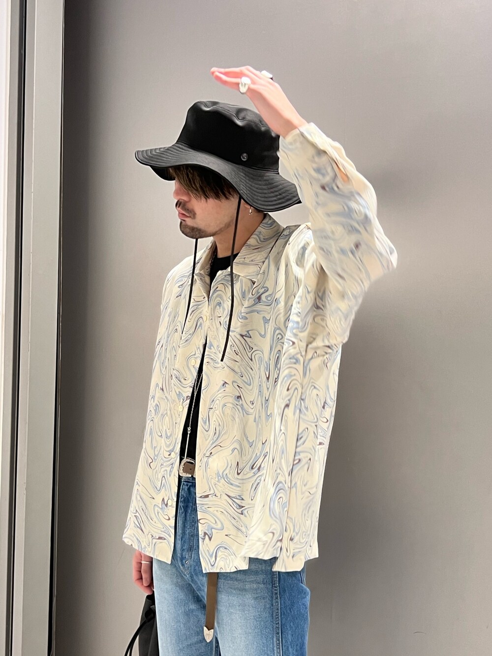 ホワイト系のシャツ/ブラウス、ブルー系のデニムパンツ、ブラック系のショルダーバッグを着用したメンズの春コーディネートの2枚目の写真