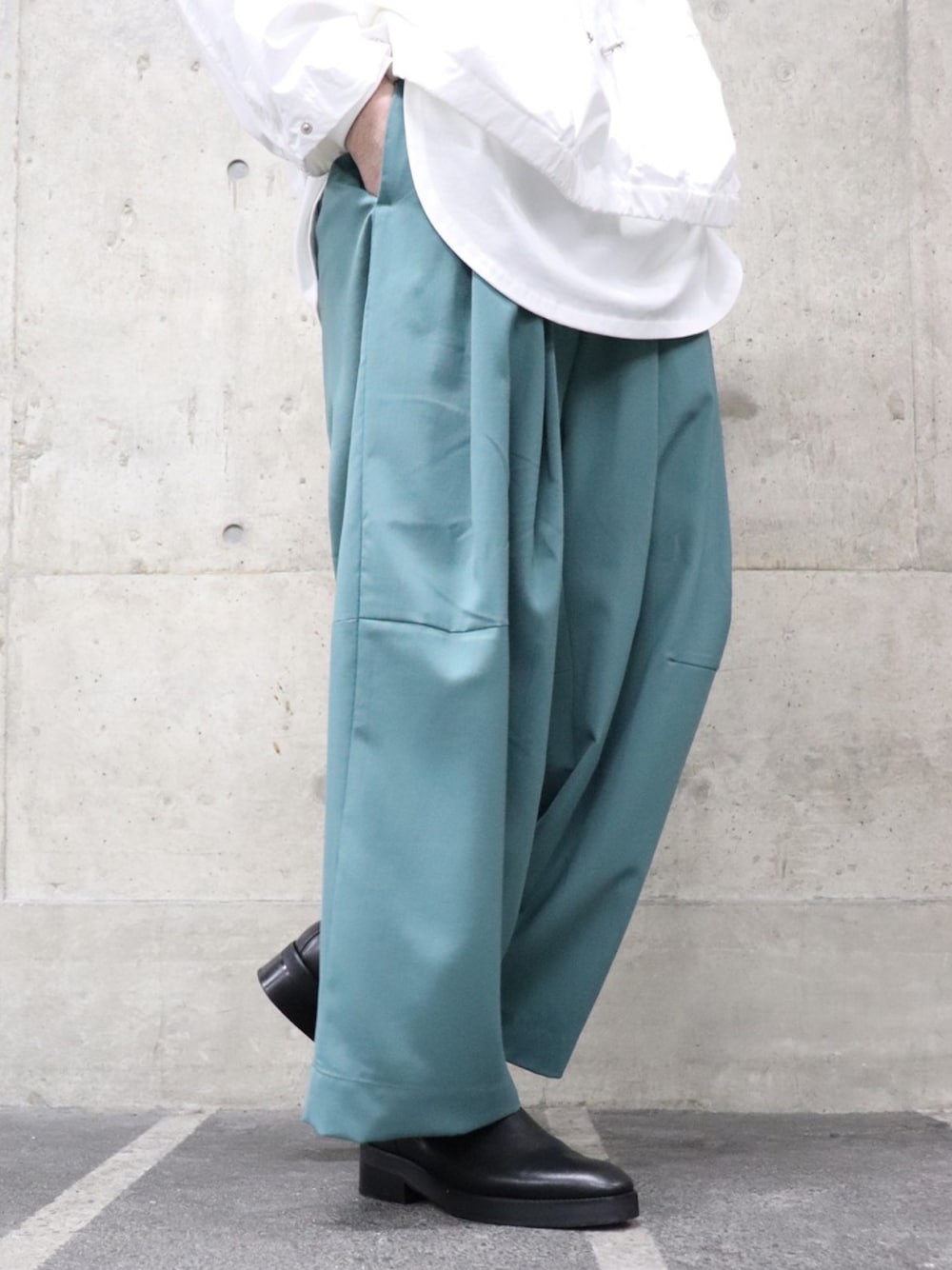 ホワイト系のマウンテンパーカー、ホワイト系のTシャツ/カットソー、グリーン系のパンツを着用したメンズの春コーディネートの4枚目の写真