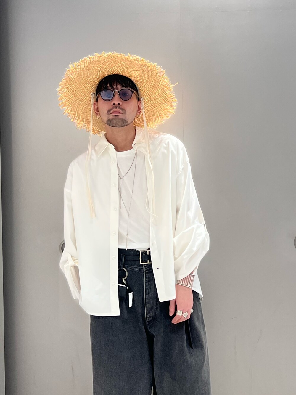 グレー系のパンツ、ブラック系のスニーカー、ホワイト系のシャツ/ブラウスを着用したメンズの春コーディネートの3枚目の写真