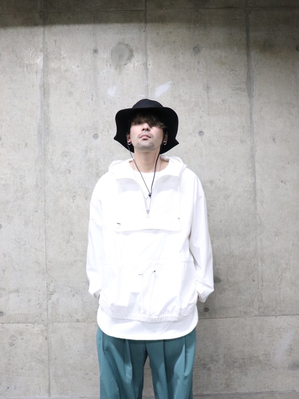 ホワイト系のマウンテンパーカー、ホワイト系のTシャツ/カットソー、グリーン系のパンツを着用したメンズの春コーディネートの3枚目の写真