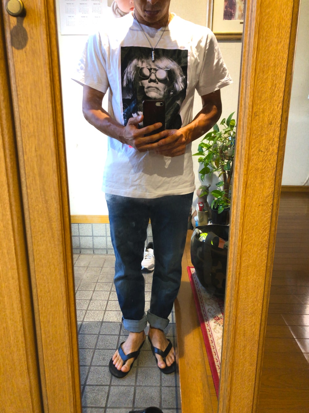 ブルー系のデニムパンツ、ブラック系のサンダル、ホワイト系のTシャツ/カットソーを着用したメンズの夏コーディネートの1枚目の写真