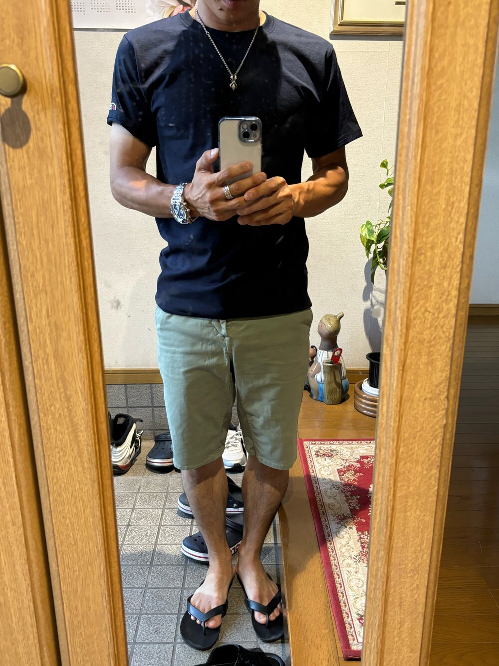 グリーン系のチノパンツ、ホワイト系のサンダル、ブルー系のトートバッグを着用したメンズの夏コーディネートの1枚目の写真