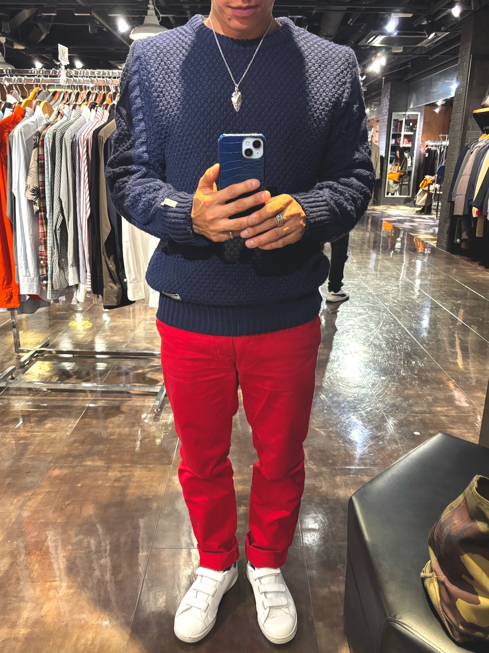 レッド系のチノパンツ、グリーン系のスニーカー、ブルー系のニット/セーターを着用したメンズの秋コーディネートの1枚目の写真