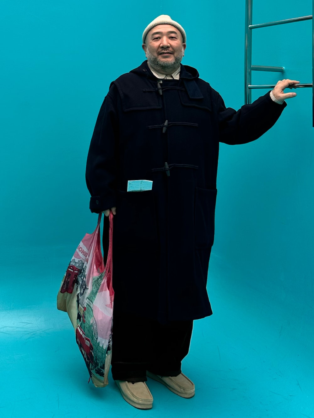 ブルー系のダッフルコート、ベージュ系のその他シューズを着用したメンズの秋コーディネートの1枚目の写真