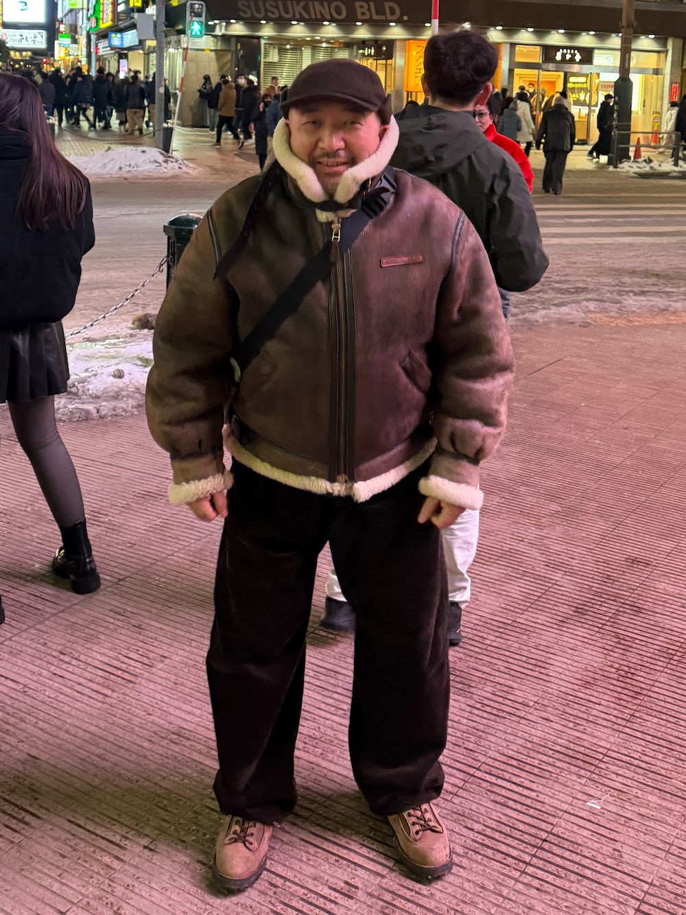 ブラウン系のムートンコート、ブラウン系のブーツを着用したメンズの冬コーディネートの1枚目の写真