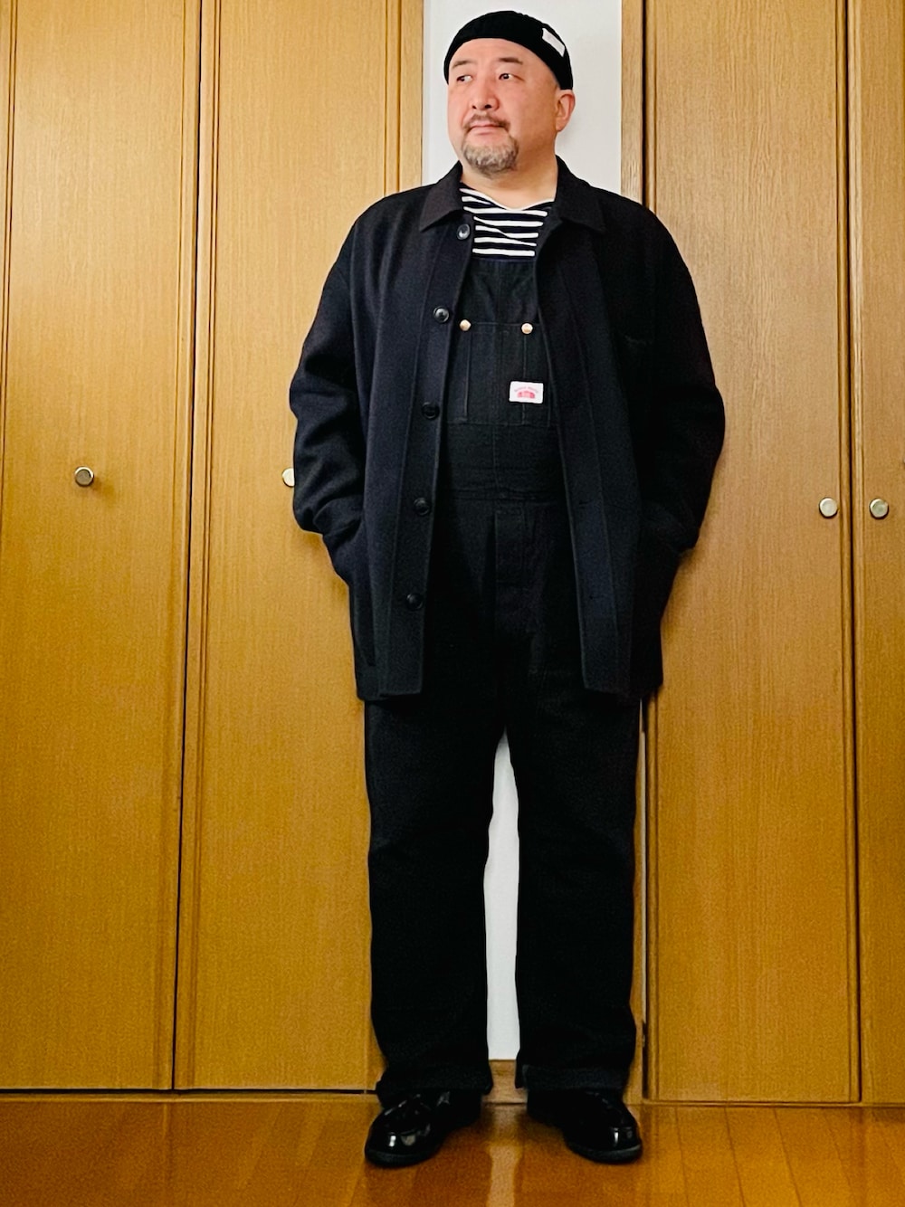 ブラック系のサロペット/オーバーオール、ブルー系のTシャツ/カットソー、グレー系のジャケット/アウターを着用したメンズの春コーディネートの1枚目の写真