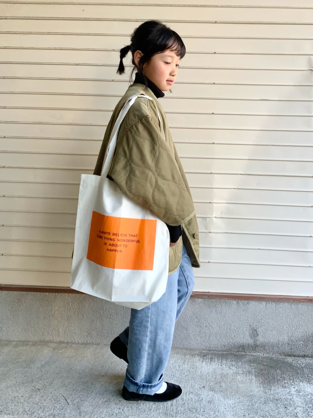 「プチプラ、キルティングジャケット、デニムパンツ、トートバッグ、ショルダーバッグ、タートルネック、休日スタイル、カジュアルコーデ、バレエシューズ、グリーン」｜「classicalelfのキッズ 袖シェルボタン付きタートルネックミドル丈無地コットンリブニット(長袖)（ニット/セーター、ブラック系）」を使った、N2さん（キッズ・127cm）の冬コーディネートの1枚目の写真