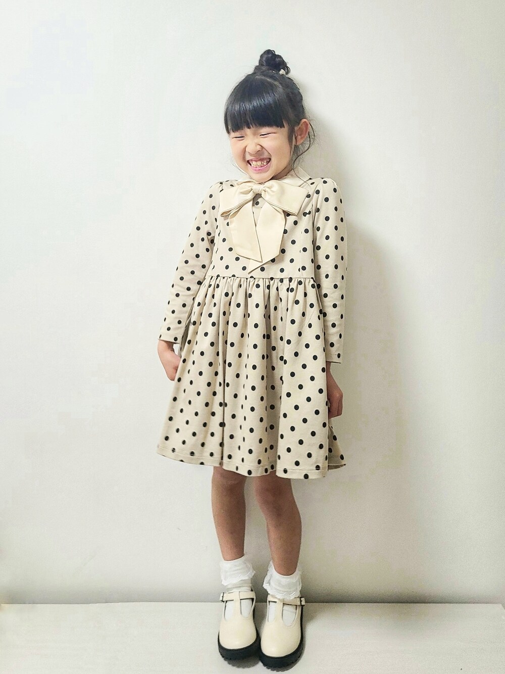 ベージュ系のワンピース、ホワイト系のシューズ、パープル系のランドセルを着用したキッズの春コーディネートの4枚目の写真