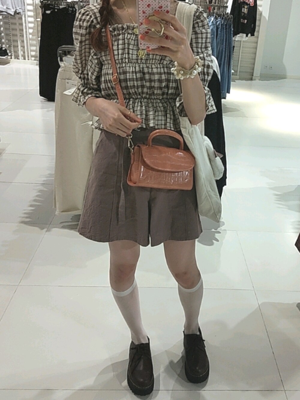 ベージュ系のシャツ/ブラウス、ピンク系のショルダーバッグ、ブラウン系のパンツを着用したレディースの秋コーディネートの1枚目の写真