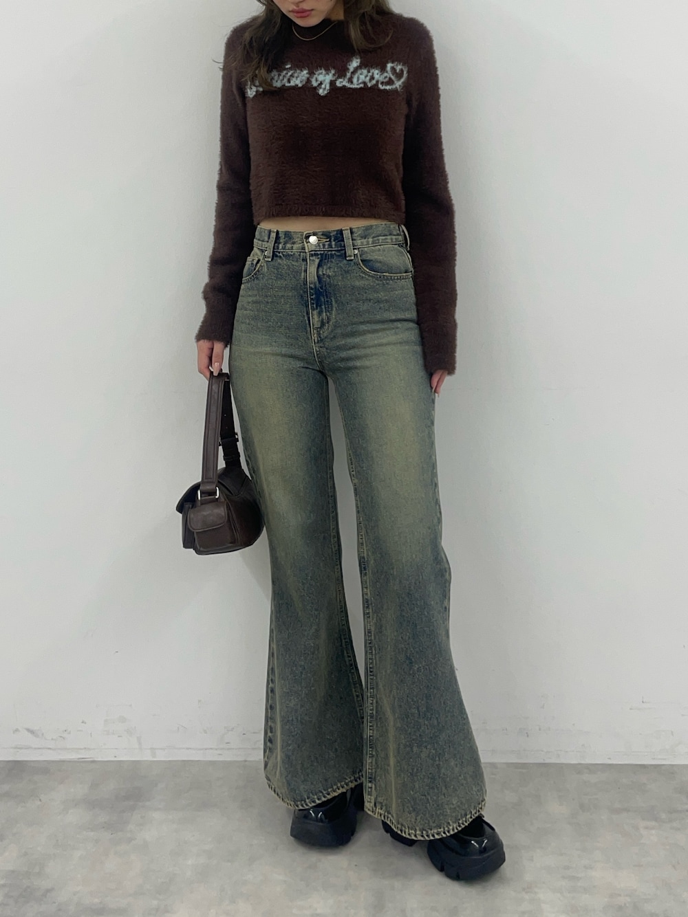 ブラウン系のニット/セーター、ブルー系のデニムパンツ、ブラック系のローファーを着用したレディースの秋コーディネートの1枚目の写真