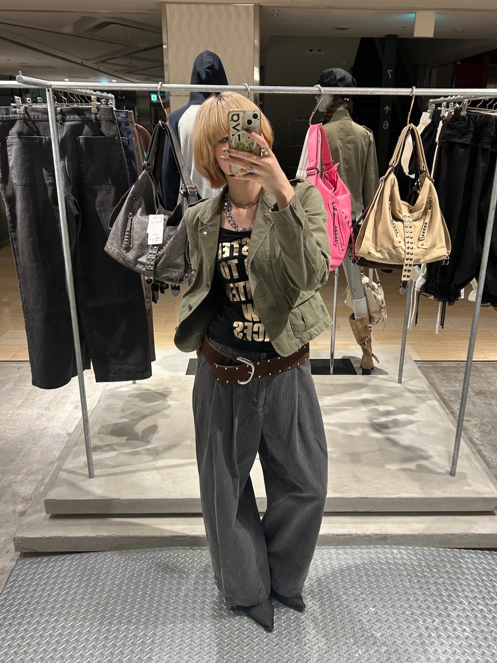 グリーン系のミリタリージャケット、ブラック系のTシャツ/カットソー、グレー系のその他パンツを着用したレディースの秋コーディネートの1枚目の写真