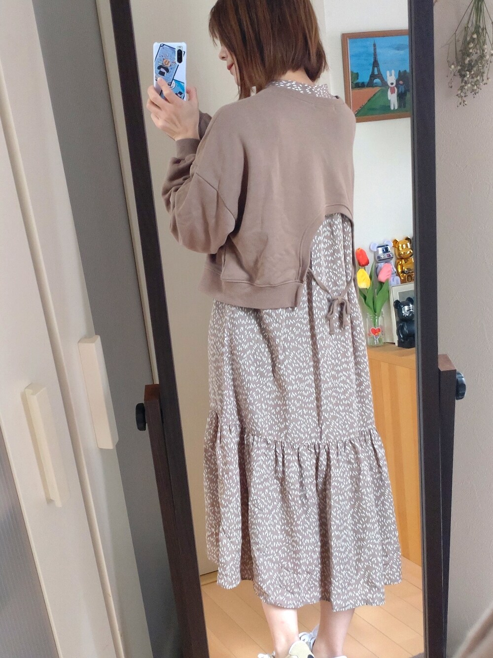 ベージュ系のシャツワンピース、ベージュ系のカーディガン/ボレロ、ベージュ系のスニーカーを着用したレディースの春コーディネートの4枚目の写真