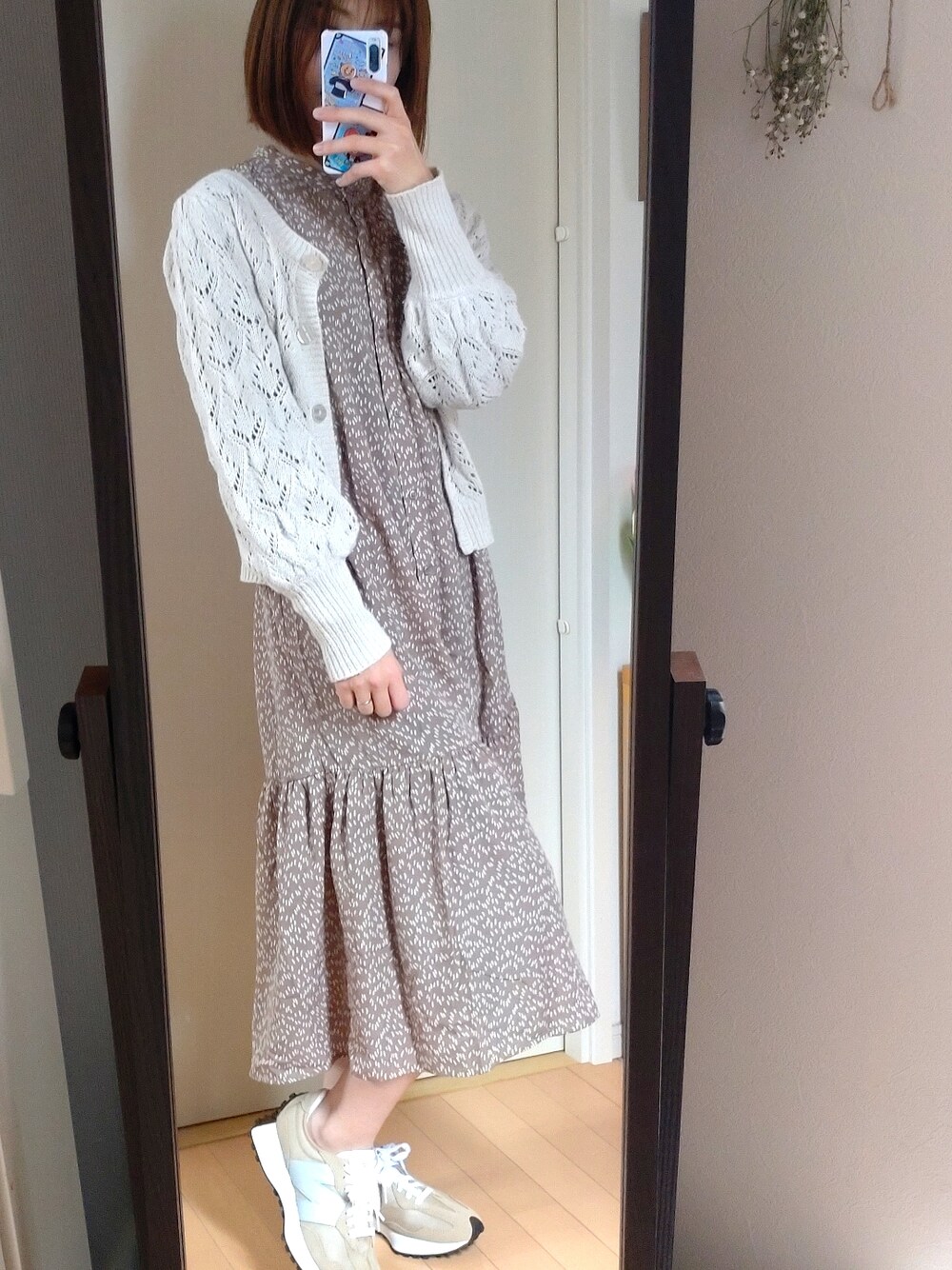 ベージュ系のシャツワンピース、ベージュ系のカーディガン/ボレロ、ベージュ系のスニーカーを着用したレディースの春コーディネートの2枚目の写真