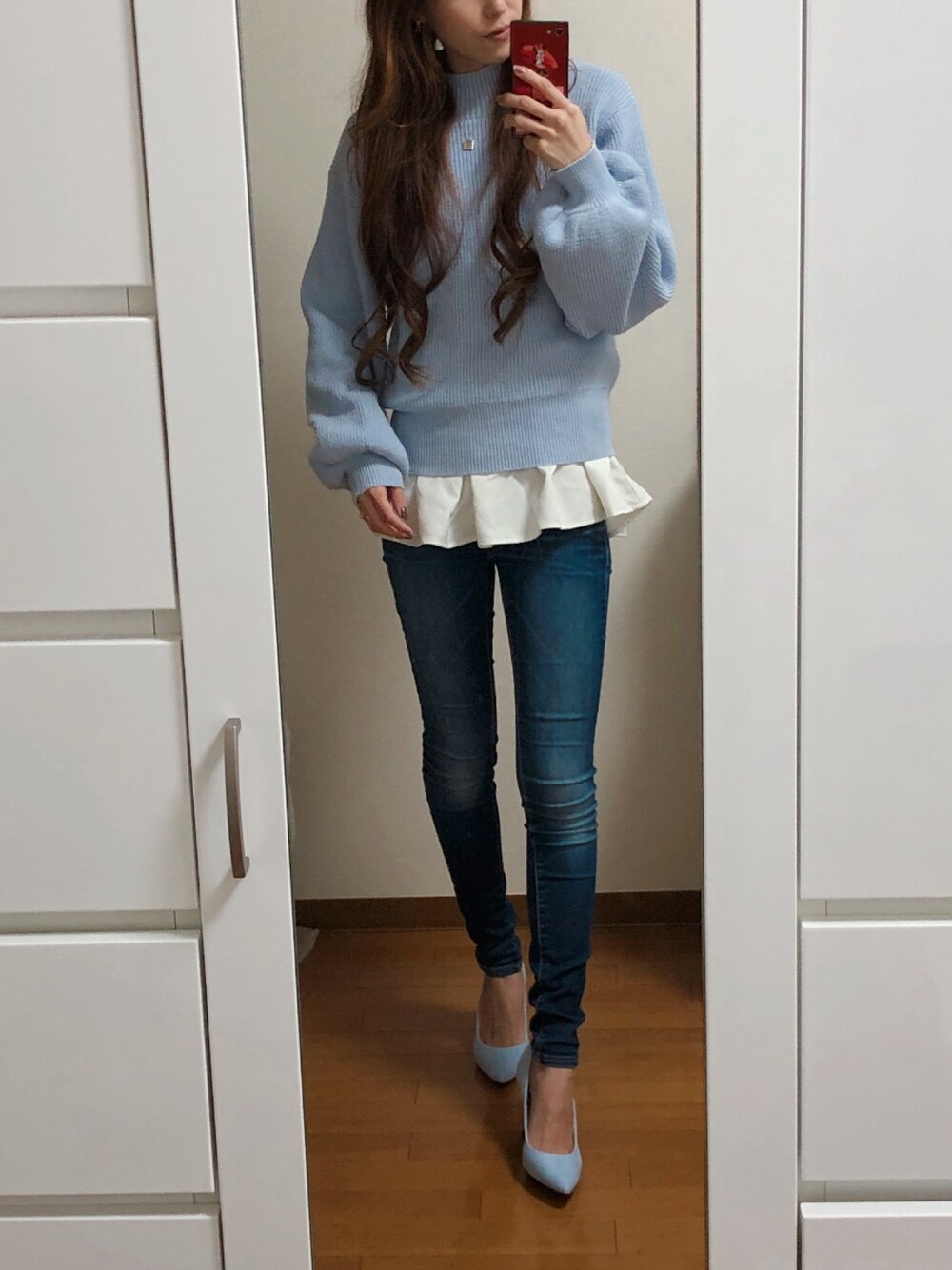 ブルー系のニット/セーター、ホワイト系のTシャツ/カットソー、ブルー系のデニムパンツを着用したレディースの冬コーディネートの1枚目の写真