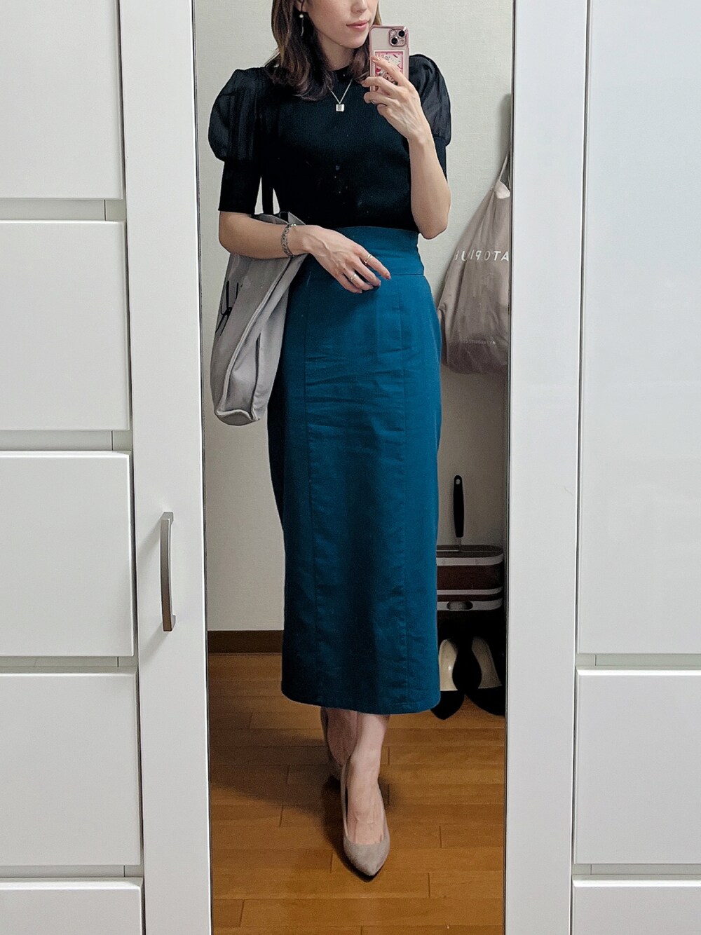 グレー系のトートバッグ、ブラック系のTシャツ/カットソー、ブルー系のスカートを着用したレディースの夏コーディネートの1枚目の写真