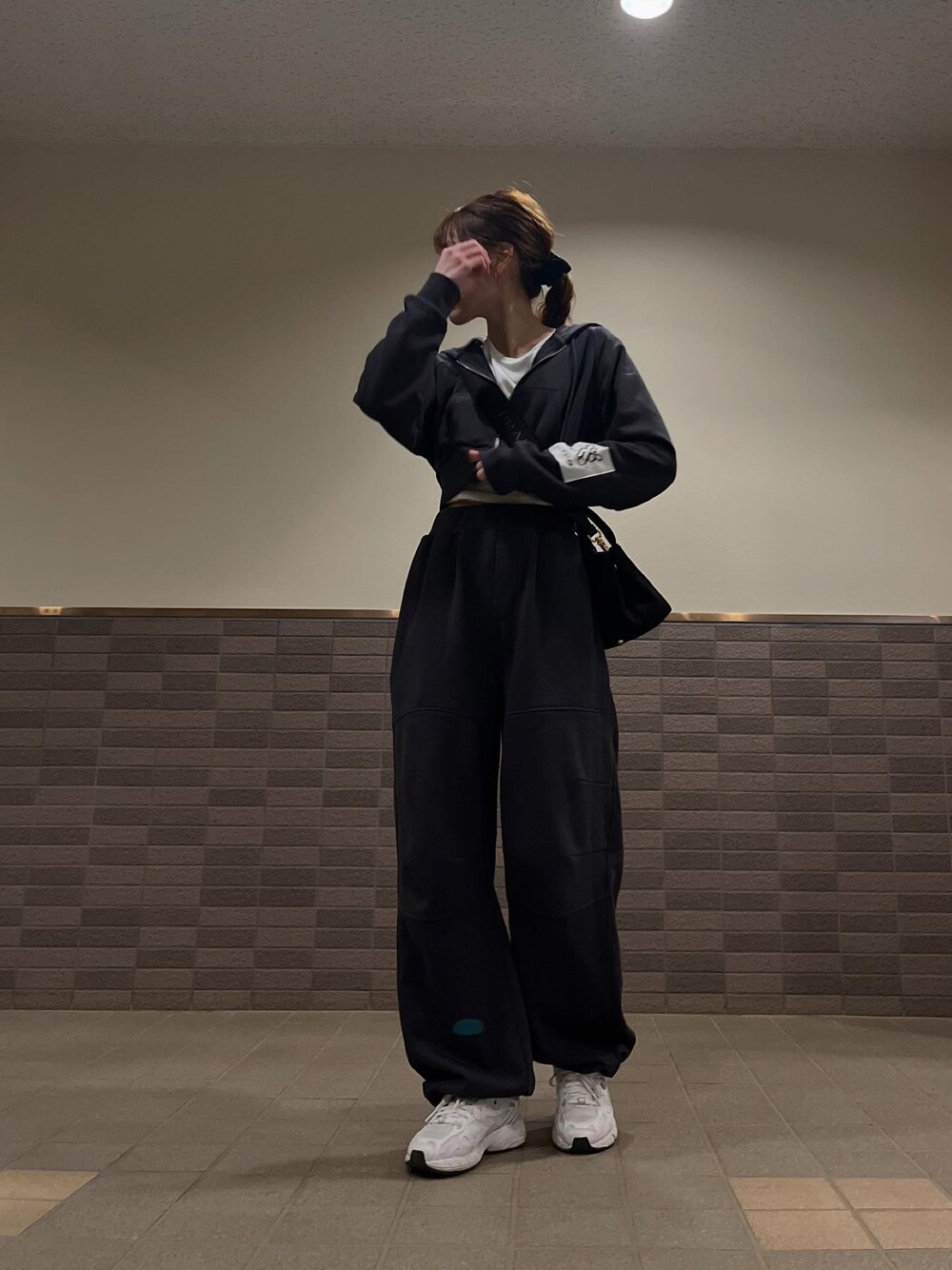 ブラック系のスウェット、ブラック系のスウェットパンツ、ホワイト系のスニーカーを着用したレディースの冬コーディネートの1枚目の写真