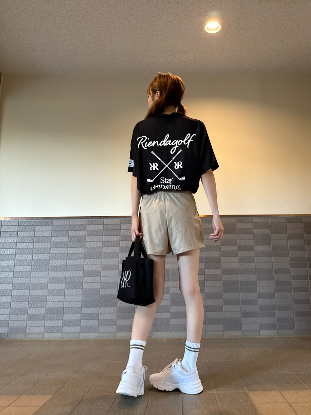 ブラック系のTシャツ/カットソー、ベージュ系のパンツ、ブラック系のトートバッグを着用したレディースの夏コーディネートの1枚目の写真