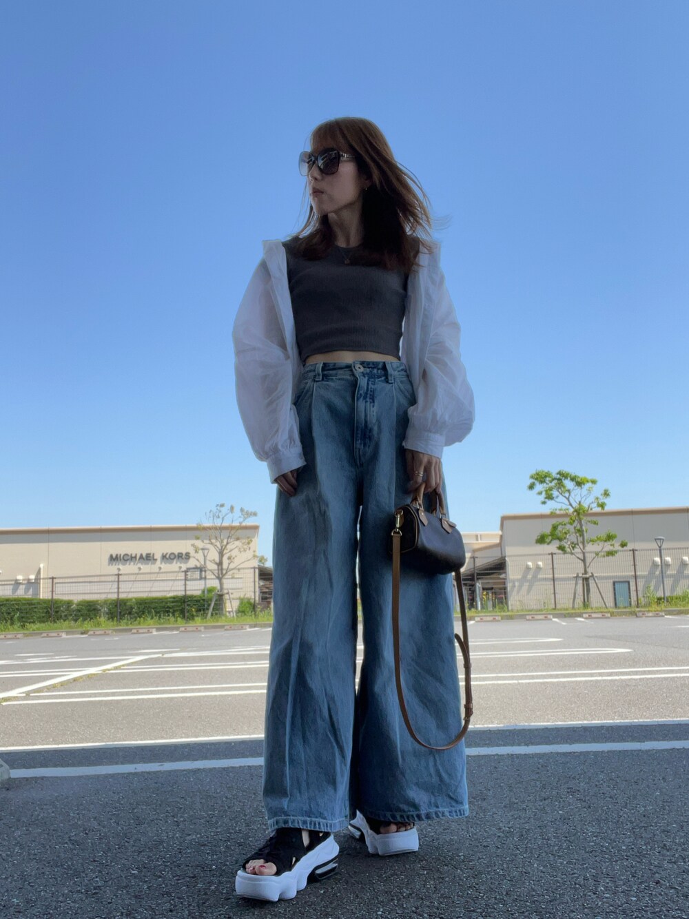 グレー系のTシャツ/カットソー、ホワイト系のシャツ/ブラウス、ブラウン系のバッグを着用したレディースの春コーディネートの1枚目の写真