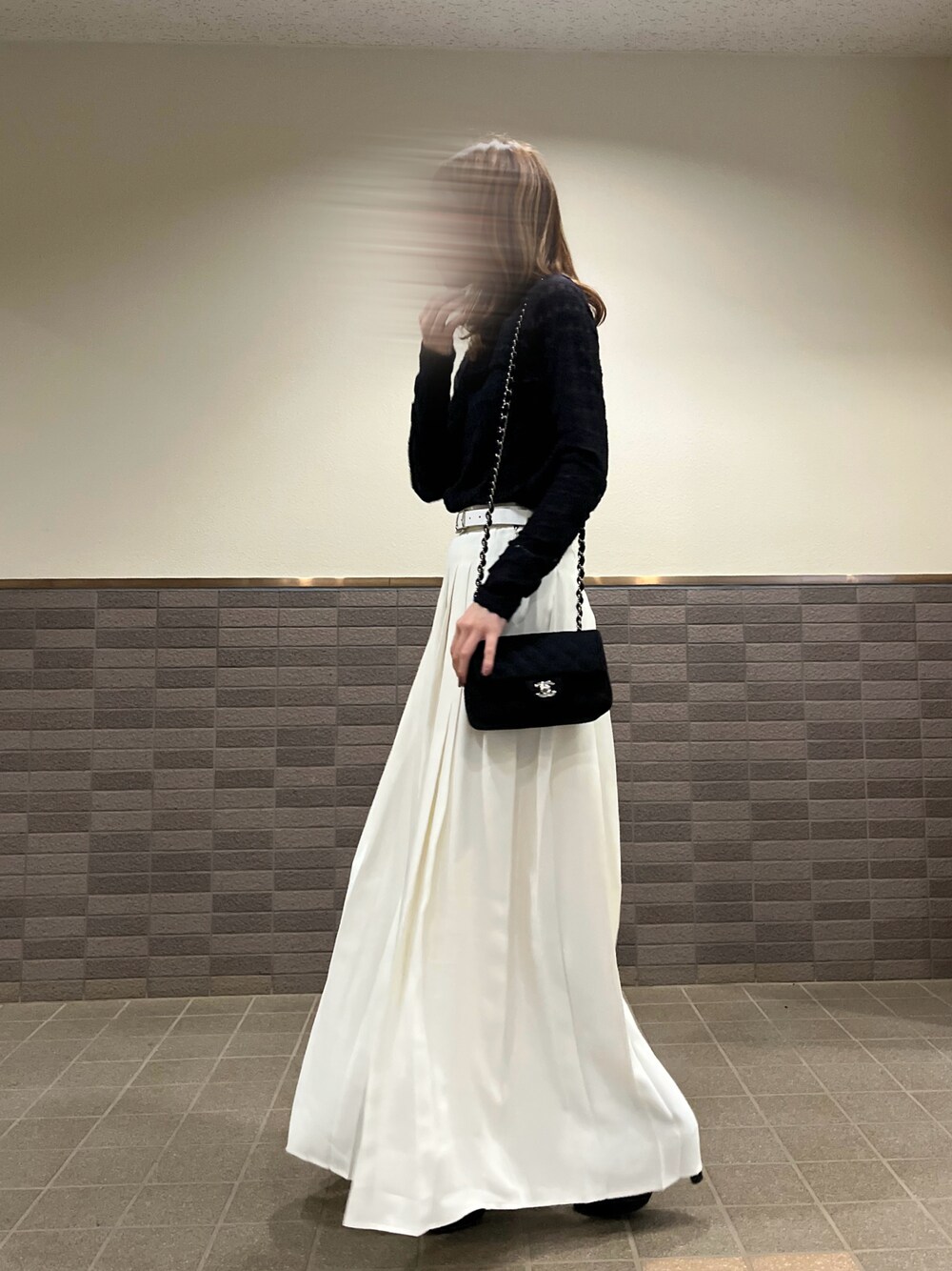 ホワイト系のスラックス、ブラック系のTシャツ/カットソー、ブラック系のショルダーバッグを着用したレディースの秋コーディネートの1枚目の写真