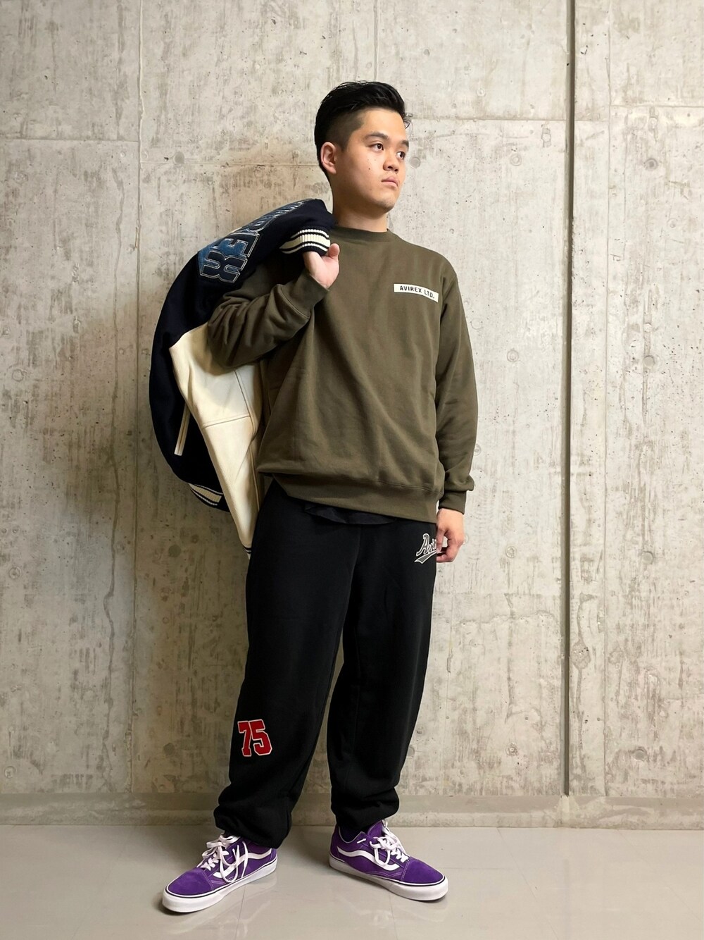 グリーン系のスウェット、ブラック系のスウェットパンツ、ブルー系のスタジャンを着用したメンズの夏コーディネートの1枚目の写真