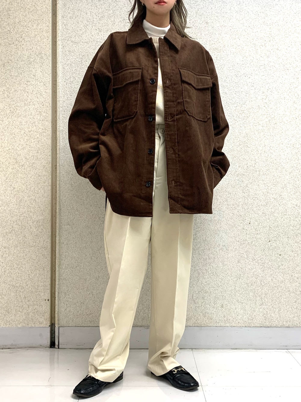 ブラウン系のブルゾン、ホワイト系のTシャツ/カットソー、ベージュ系のスラックスを着用したレディースの冬コーディネートの1枚目の写真