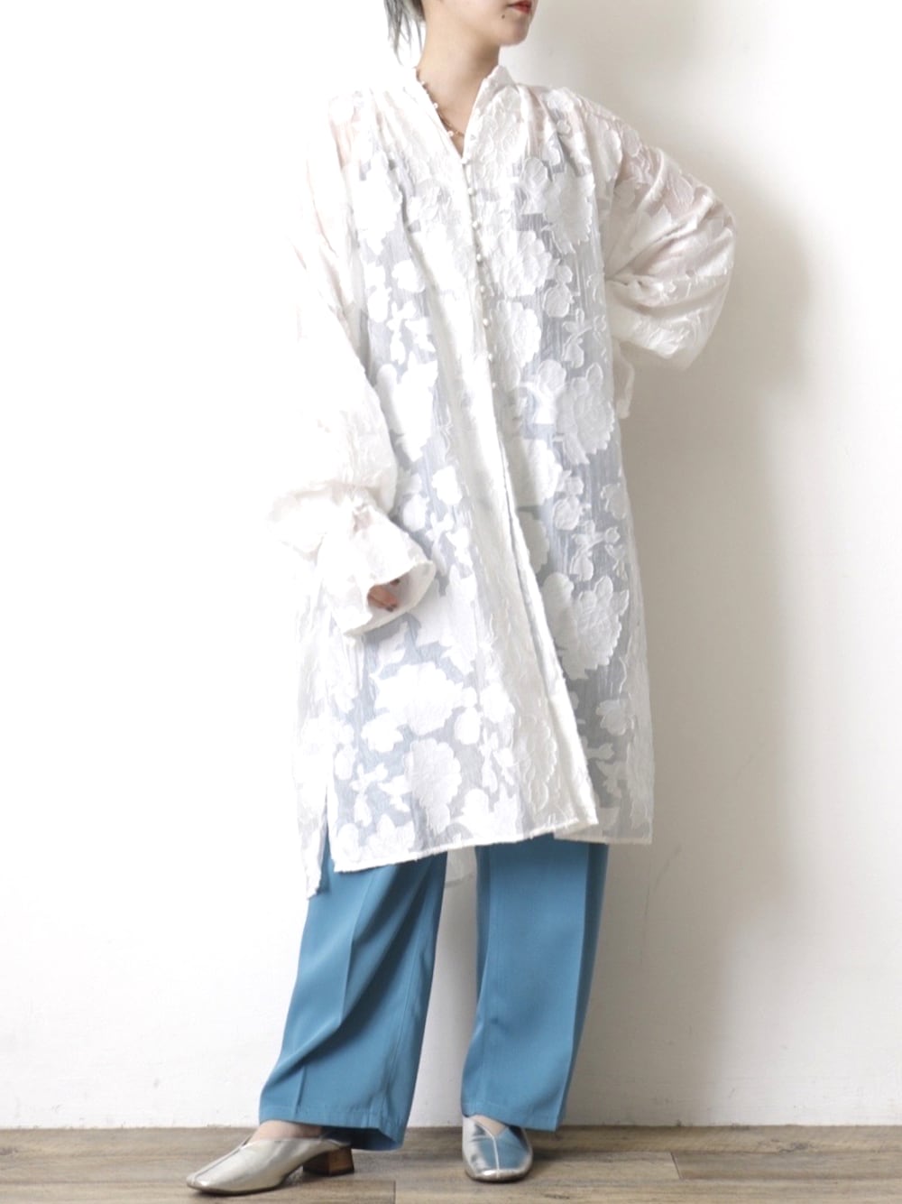 ホワイト系のシャツワンピース、ブルー系のスラックスを着用したレディースの夏コーディネートの1枚目の写真