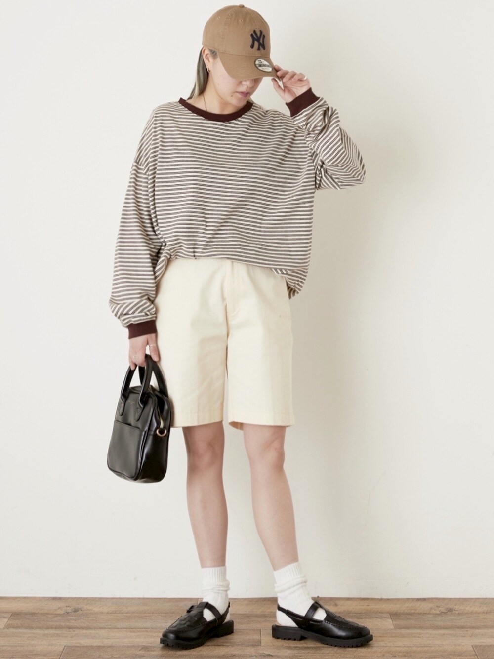 ホワイト系のTシャツ/カットソー、ブラック系のボストンバッグを着用したレディースの春コーディネートの1枚目の写真