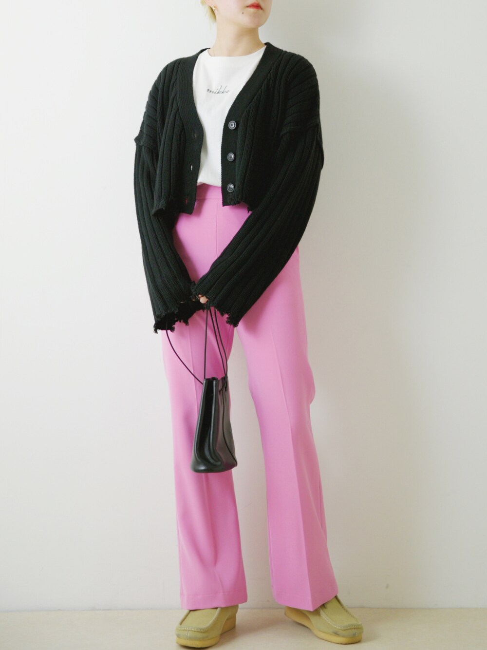 ピンク系のスラックス、ベージュ系のブーツを着用したレディースの春コーディネートの1枚目の写真