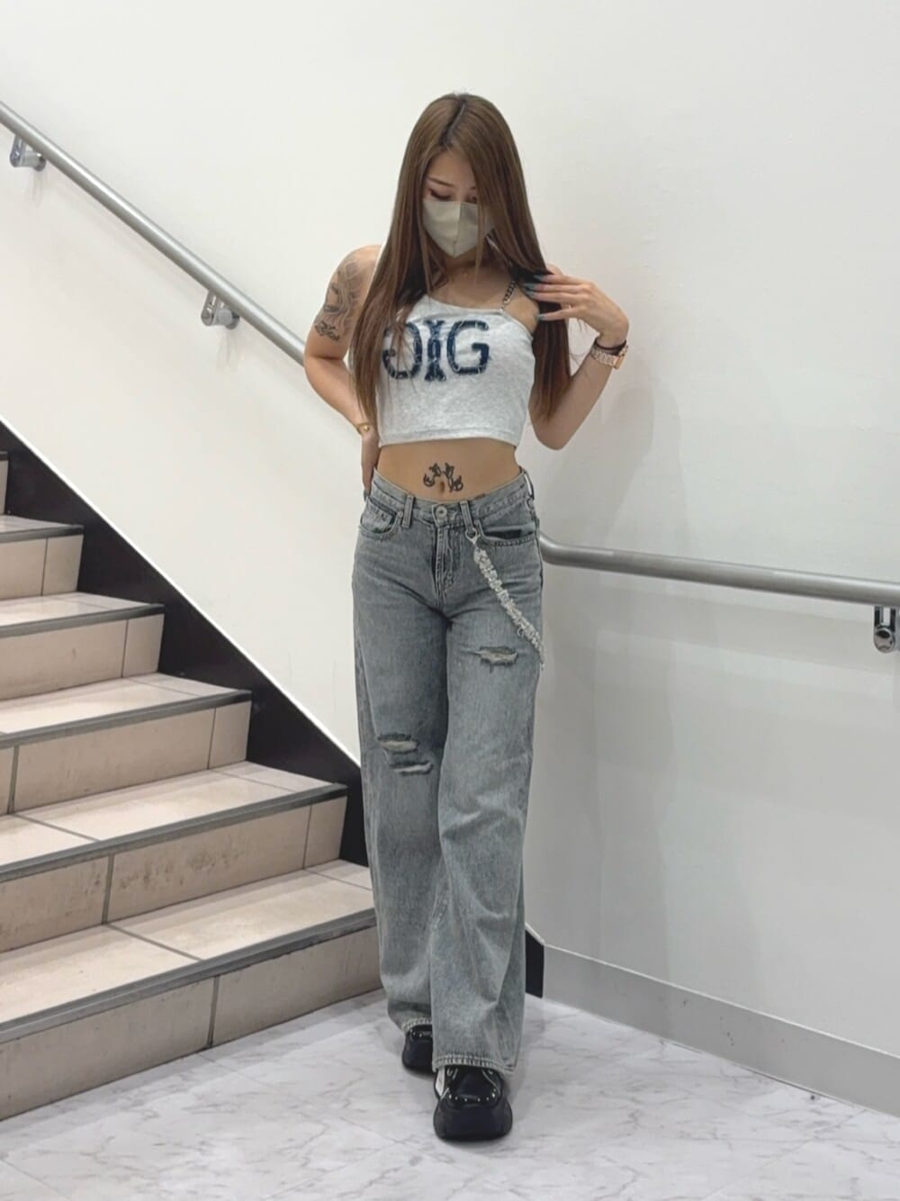 ブラック系のスニーカー、グレー系のタンクトップ、ブルー系のデニムパンツを着用したレディースの夏コーディネートの1枚目の写真