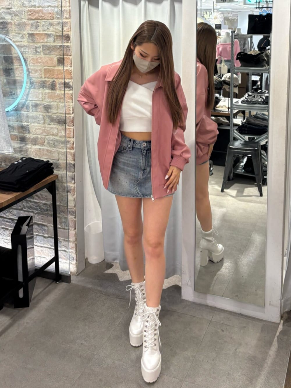 ピンク系のブルゾン、ホワイト系のTシャツ/カットソー、ブルー系のデニムスカートを着用したレディースの冬コーディネートの1枚目の写真