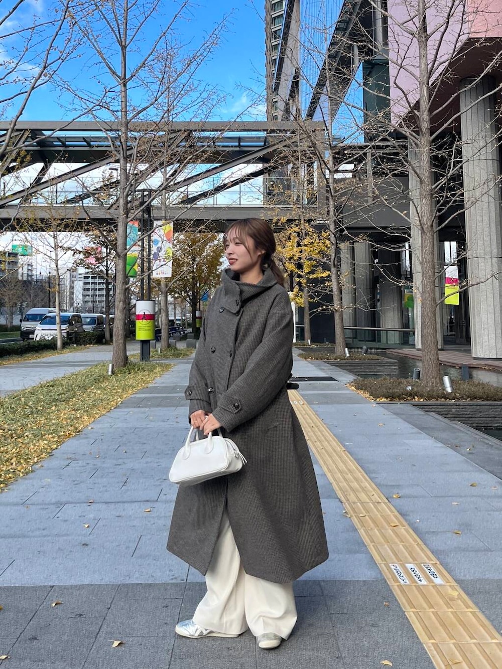 ブラウン系のその他アウター、ホワイト系のその他パンツ、ホワイト系のボストンバッグを着用したレディースの冬コーディネートの1枚目の写真