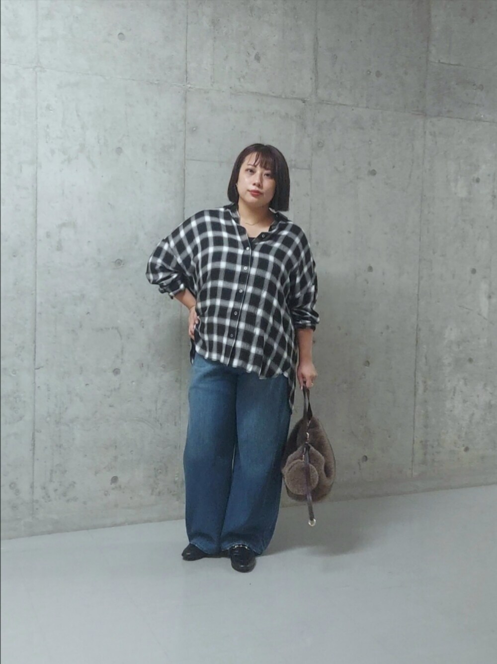 ブラック系のシャツ/ブラウス、ブルー系のデニムパンツ、ブラック系のローファーを着用したレディースの秋コーディネートの1枚目の写真