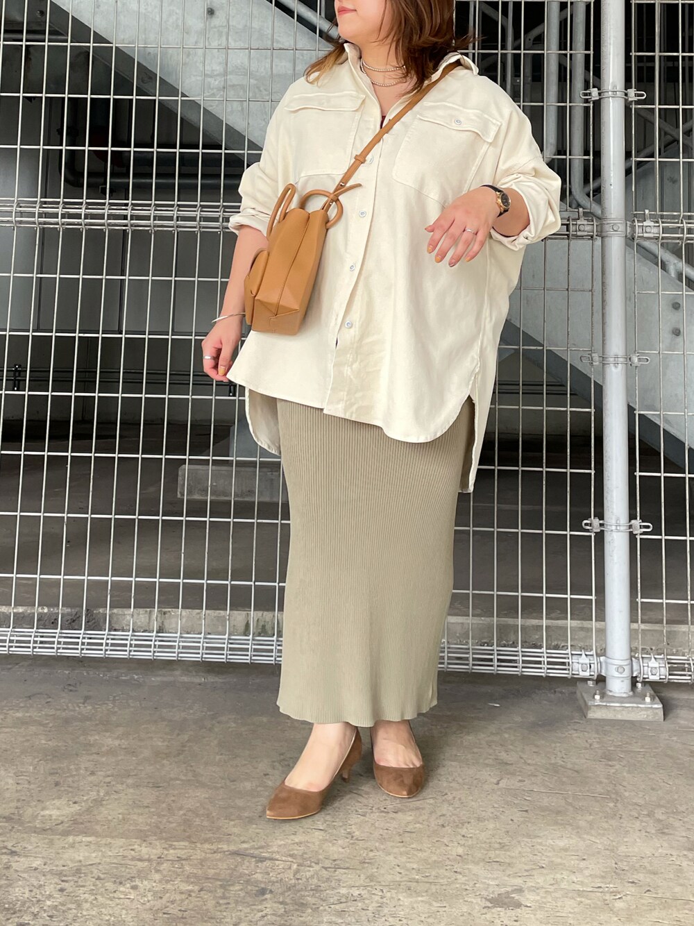 ブラウン系のパンプス、グリーン系のスカート、ホワイト系のシャツ/ブラウスを着用したレディースの秋コーディネートの1枚目の写真