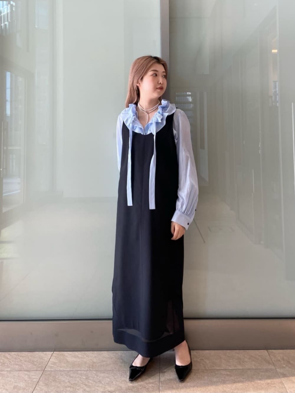 ブラック系のパンプス、ブルー系のシャツ/ブラウス、ブラック系のワンピースを着用したレディースの冬コーディネートの1枚目の写真
