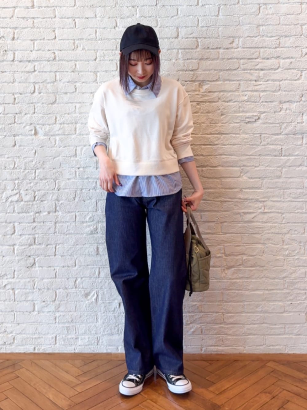 ブルー系のデニムパンツ、ホワイト系のスウェットを着用したレディースの春コーディネートの1枚目の写真