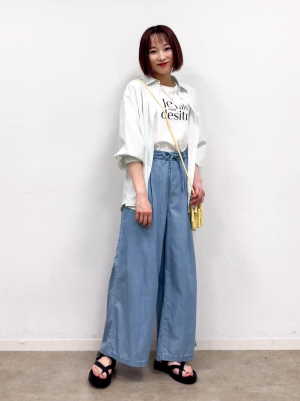 イエロー系のショルダーバッグ、ブルー系のその他パンツ、グリーン系のシャツ/ブラウスを着用したレディースの春コーディネートの1枚目の写真