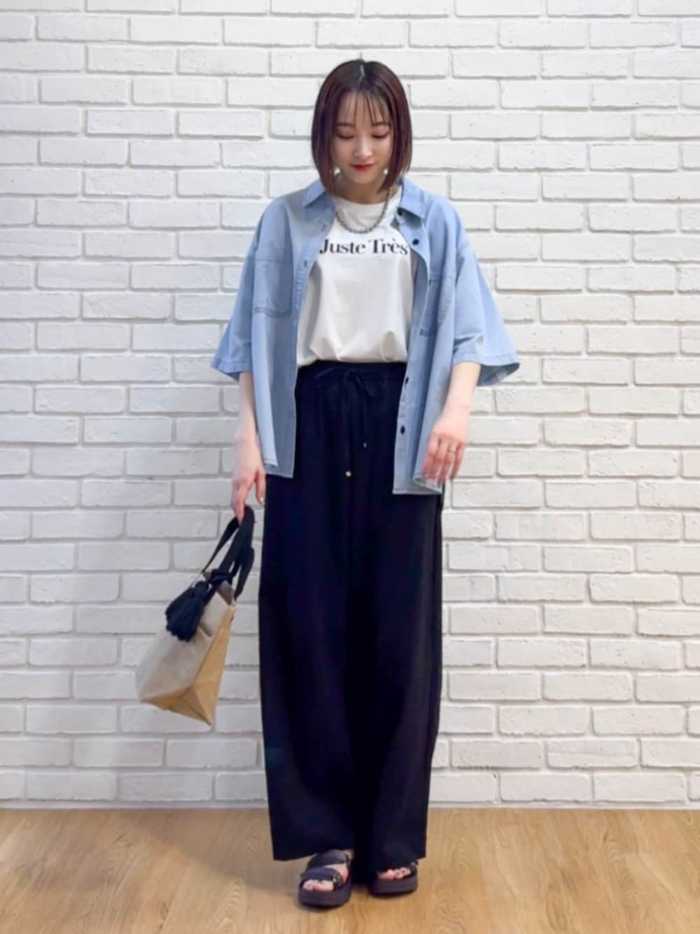 ホワイト系のTシャツ/カットソー、ブラック系のトートバッグ、パープル系のサンダルを着用したレディースの夏コーディネートの1枚目の写真