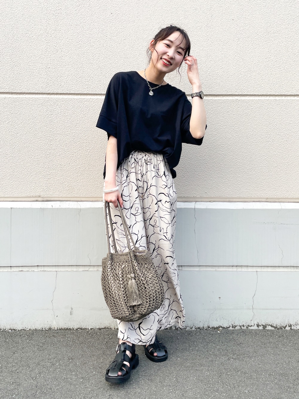 ベージュ系のその他パンツ、ブラック系のサンダル、ブラウン系のトートバッグを着用したレディースの夏コーディネートの1枚目の写真