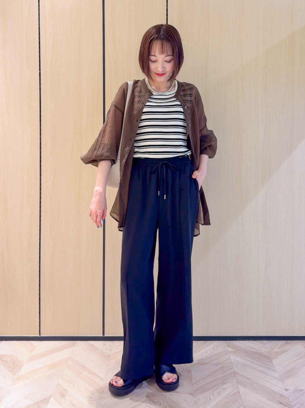 ブラウン系のシャツ/ブラウス、ベージュ系のニット/セーター、ブラック系のその他パンツを着用したレディースの夏コーディネートの1枚目の写真