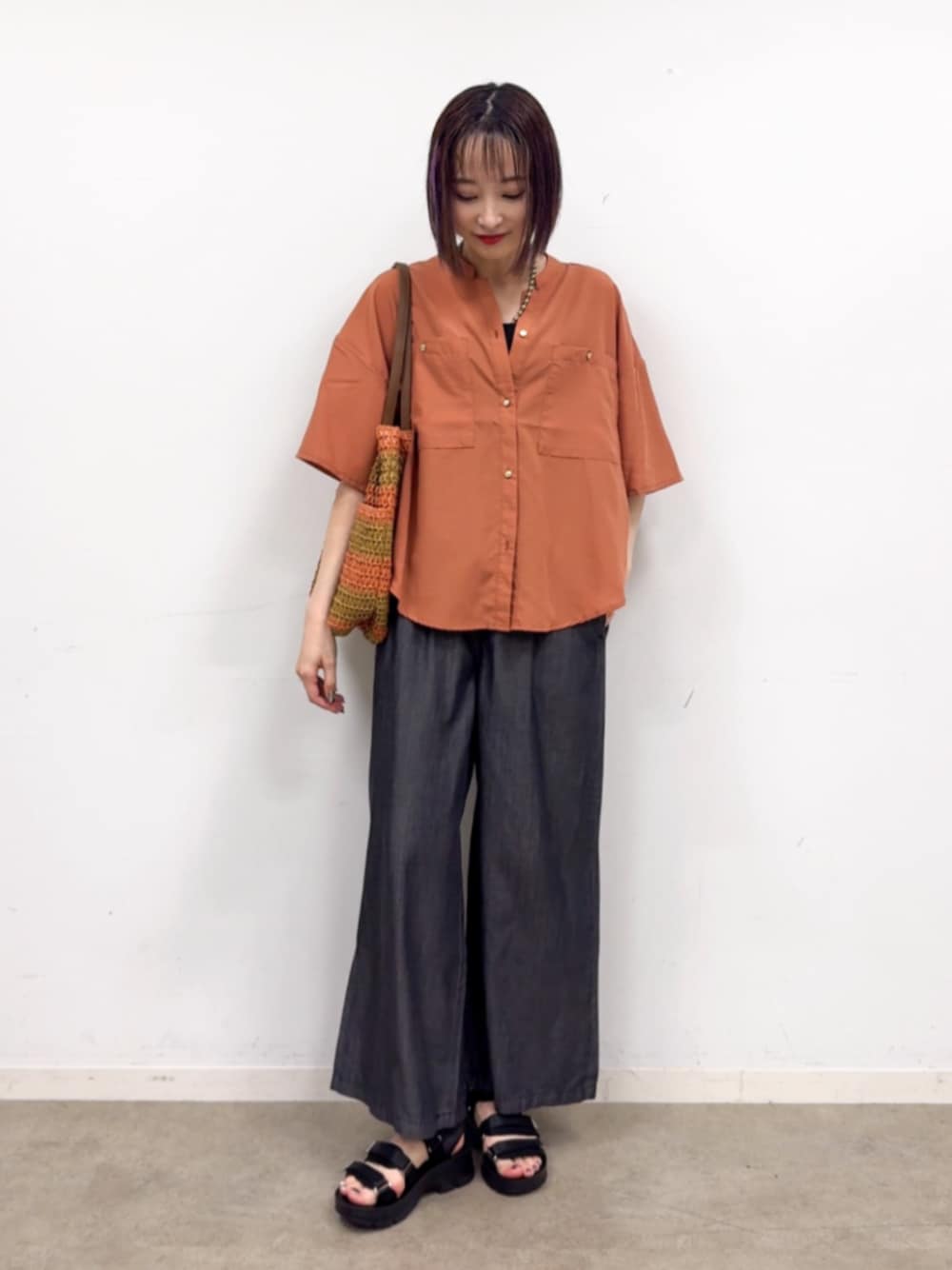 ブラック系のその他パンツ、ブラック系のサンダル、オレンジ系のシャツ/ブラウスを着用したレディースの夏コーディネートの1枚目の写真