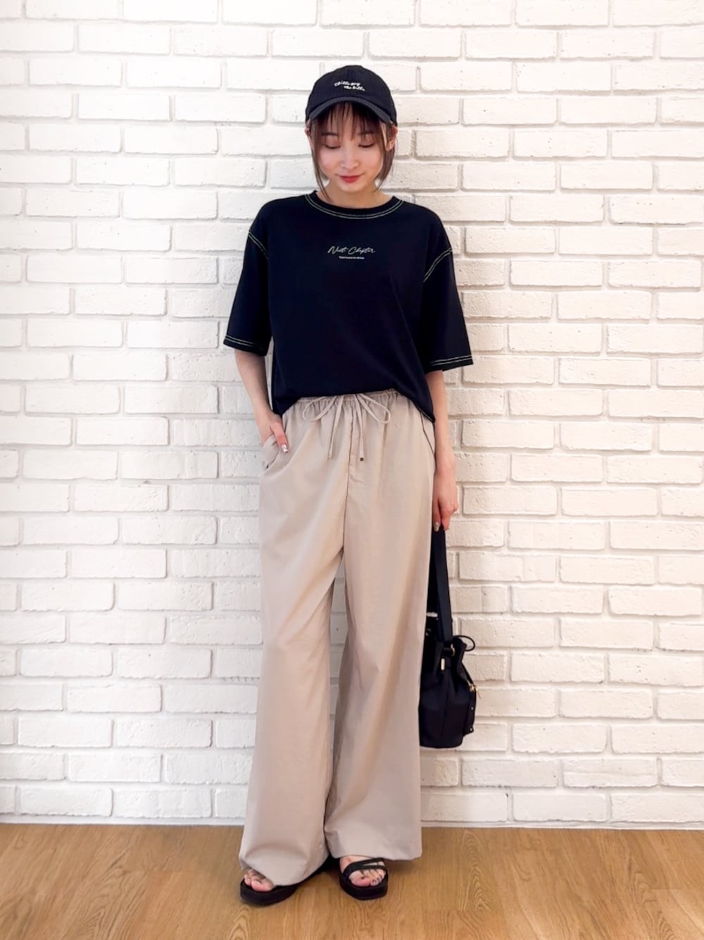 ブラック系のTシャツ/カットソー、ベージュ系のその他パンツ、ブラック系のサンダルを着用したレディースの夏コーディネートの1枚目の写真