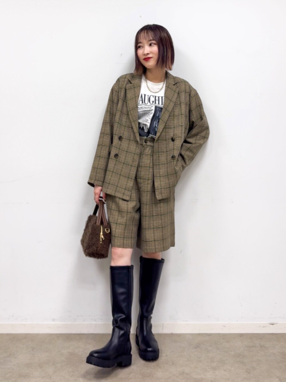 ホワイト系のTシャツ/カットソー、ブラウン系のショルダーバッグ、ブラック系のブーツを着用したレディースの秋コーディネートの1枚目の写真
